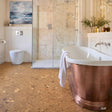Bathroom with a copper bathtub and cork tile floor
